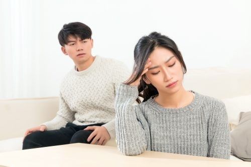 A,Beautiful,Young,Asian,Couple,Is,Sitting,On,The,Sofa.