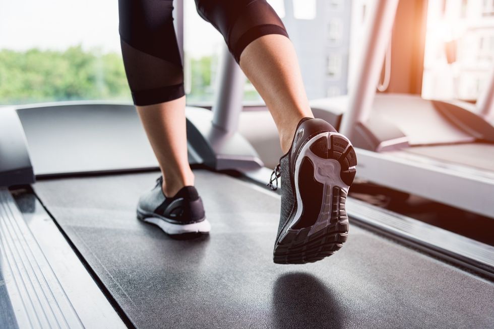 A close up of a person's feet as they walk on a treadmill