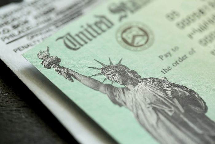 A closeup of a social security check from the U.S. government sitting on top of the envelope it was mailed in