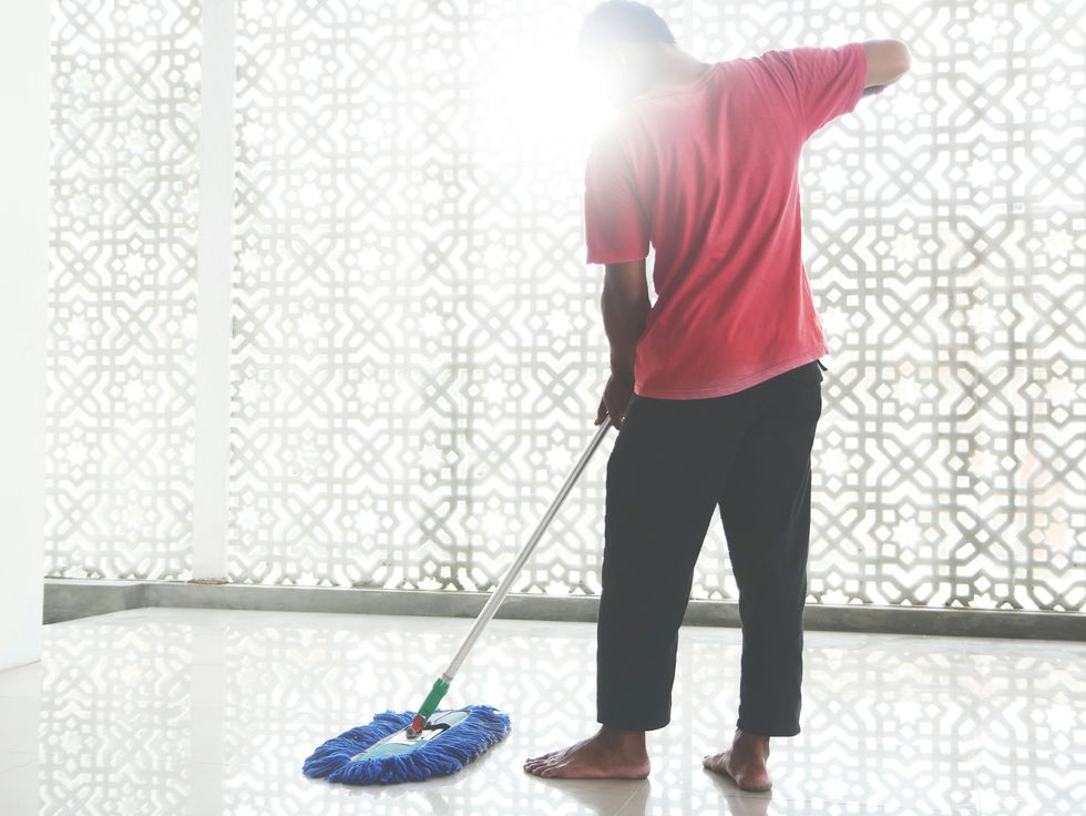 a man mops the floor as part of spring cleaning