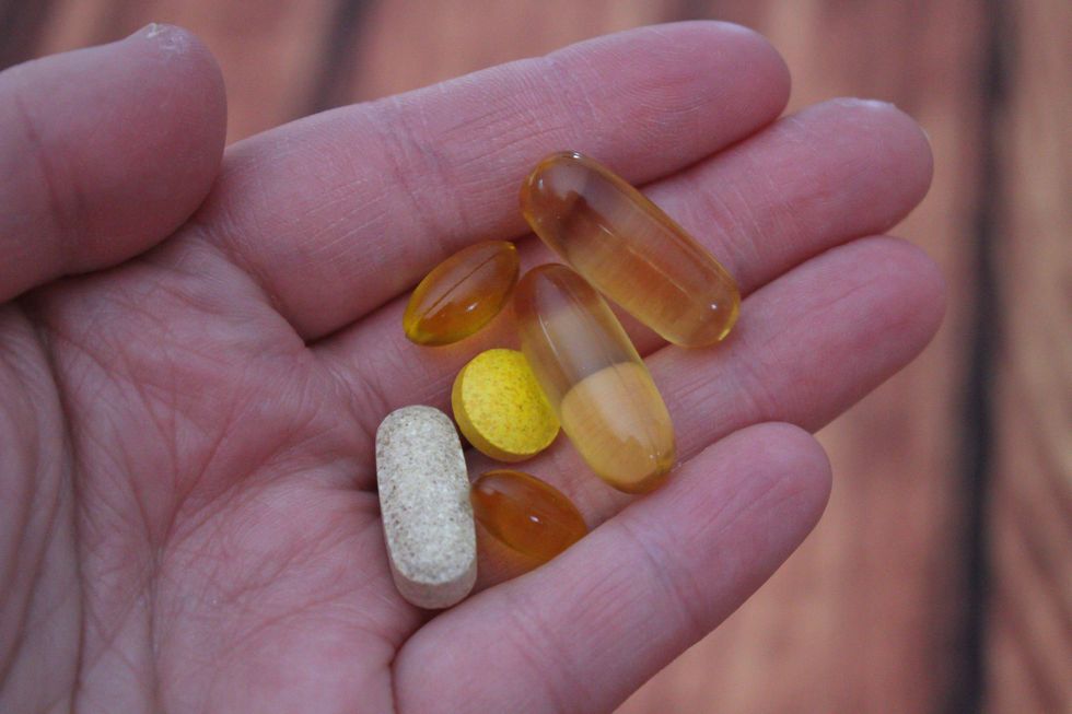 a person holds medications that they may take with vitamins