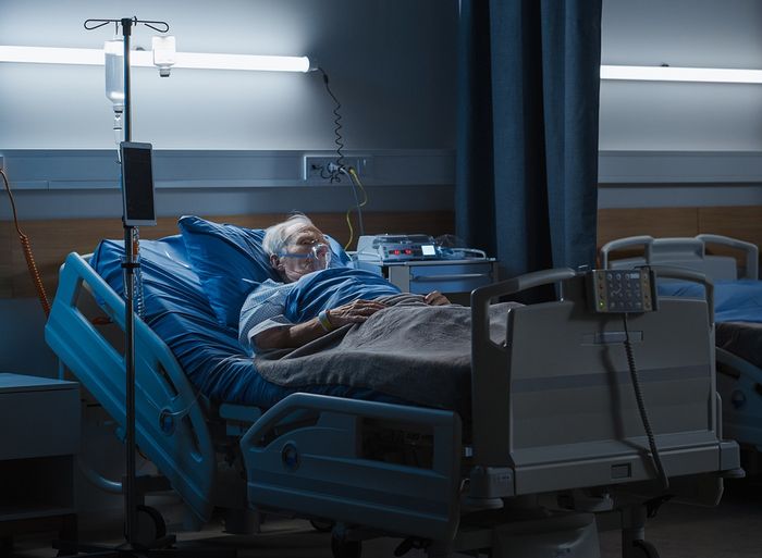 A senior man in a hospital bed