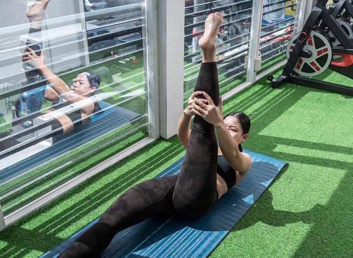 A woman does a hamstring stretch lying down on her back