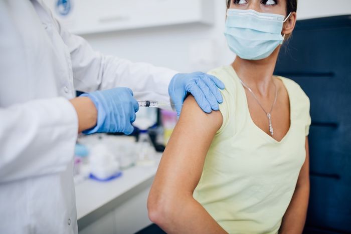 A woman receives a dose of COVID vaccine