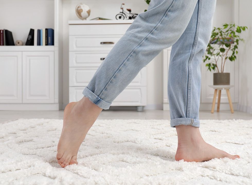 A woman's feet walking on a soft white rug