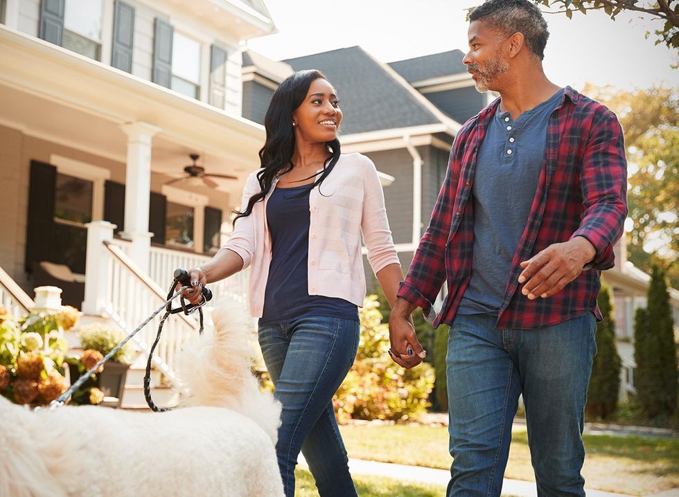 A young couple take their dog for a walk