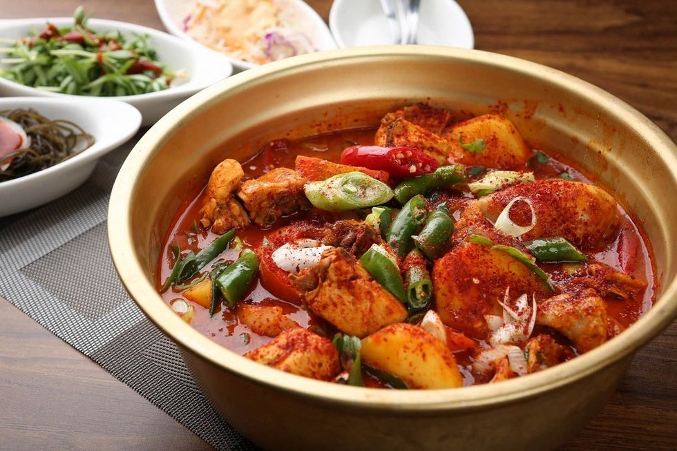 Bowl of spicy dish with chili pepper powder and chicken