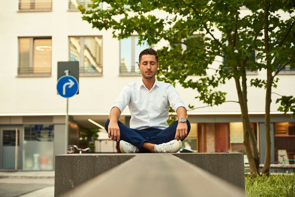 business man does deep breathing and meditation during a lunch break