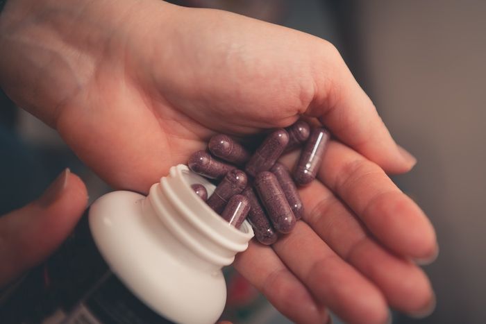 closeup of a person pouring elderberry supplements into their hand