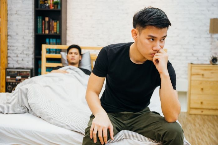 couple having argument with each other in bedroom.