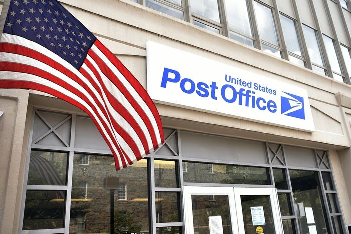 entrance to a post office with an American flag in front