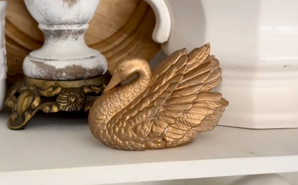 gold swan figurine on a shelf