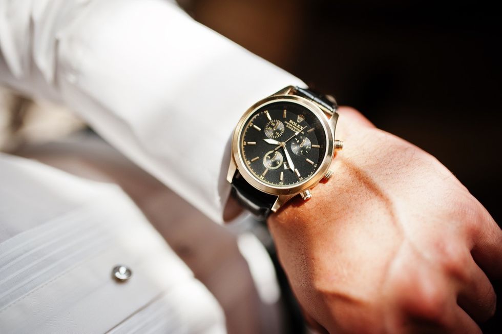 Man looking on luxury watches Rolex on his hand.