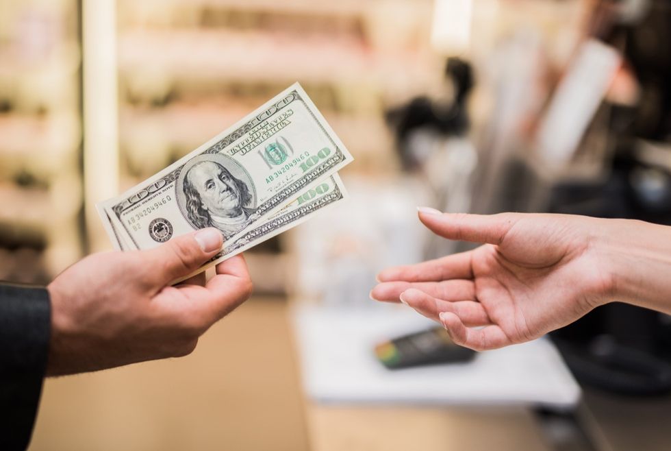 man paying with cash in store