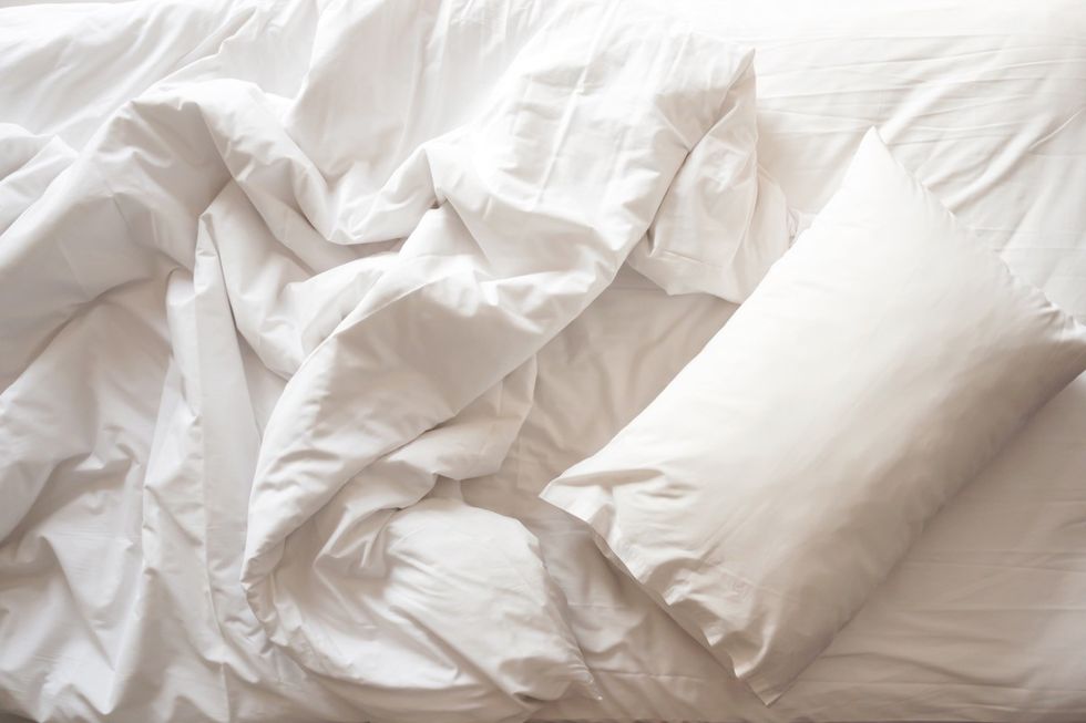 Messy bed. White pillow with blanket on bed unmade. Concept of relaxing after morning.