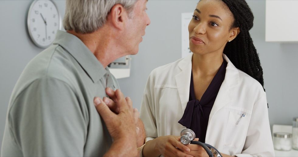 older man talking to young female doctor, heart health risks