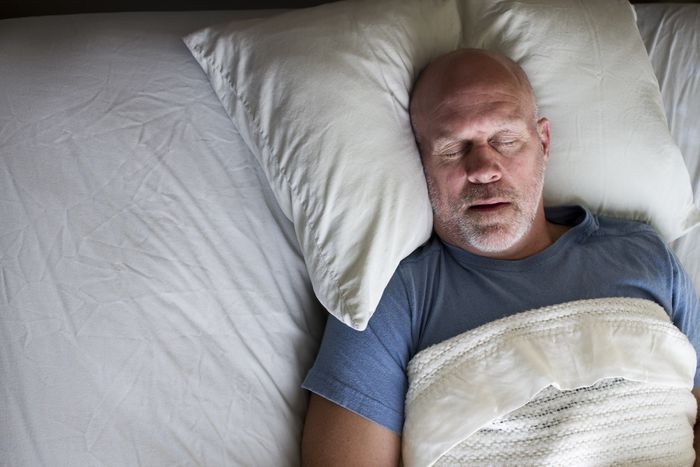 Overhead photo of a man sleeping in a bed.