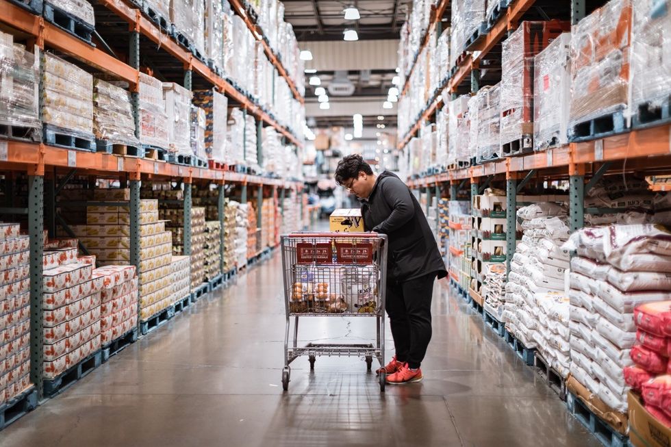 people with carts in Costco Wholesale. Costco is an American multinational corporation which operates a chain of membership only