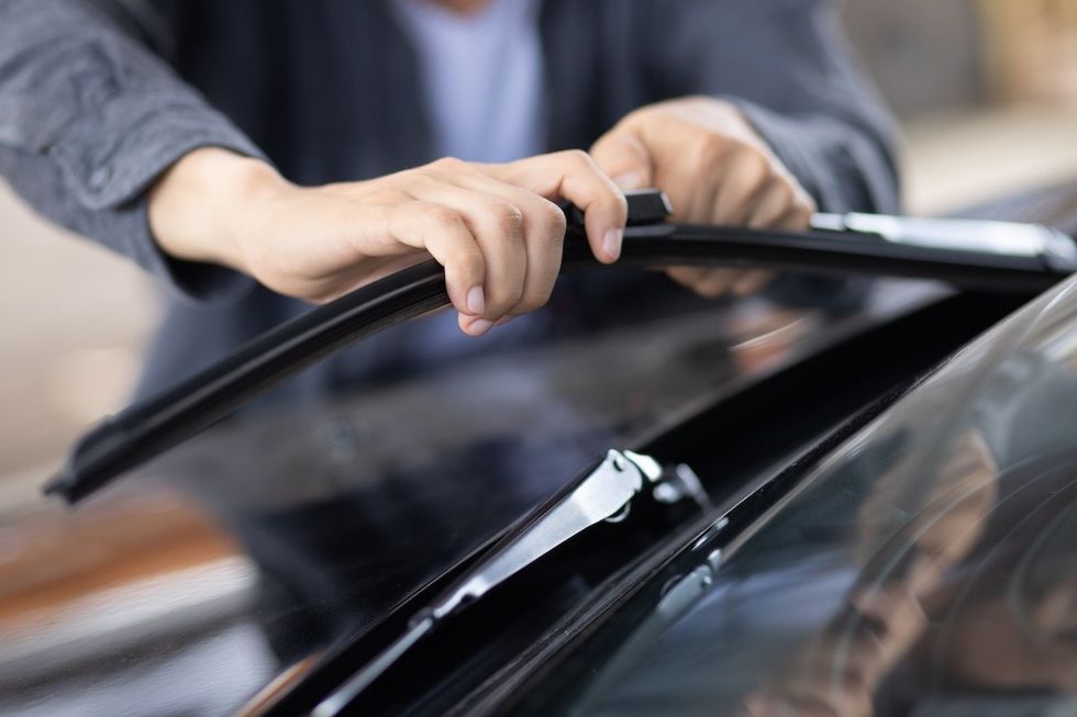 person replacing windshield wipers