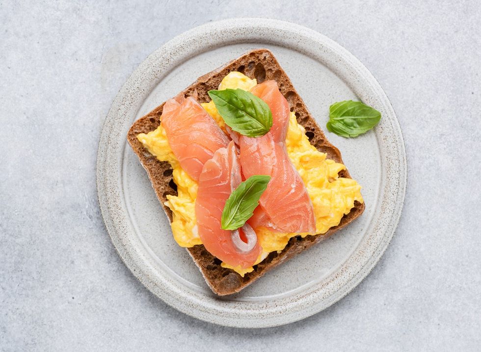 Scrambled eggs and smoked salmon on a piece of whole wheat toast