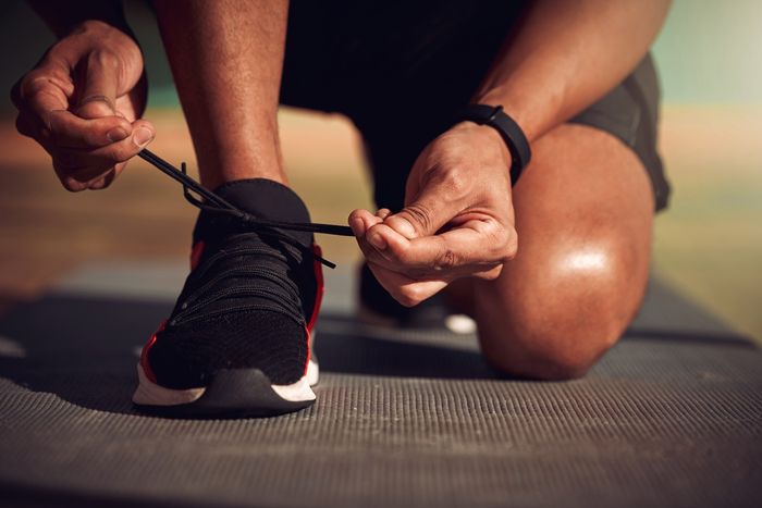 Shot of a man tying his laces before running