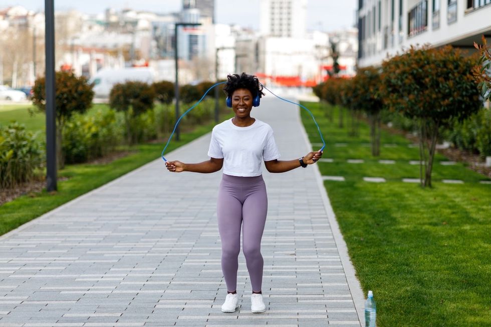 smiling woman outside jumping rope