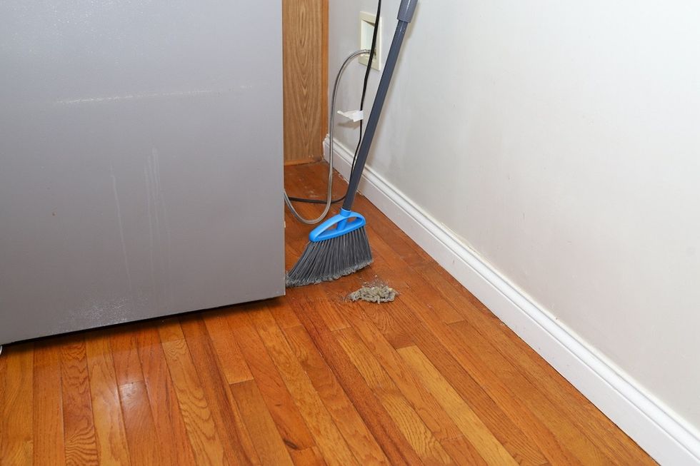 sweeping behind fridge