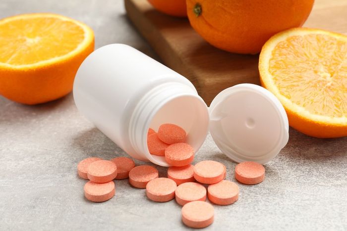 vitamin C supplements next to oranges