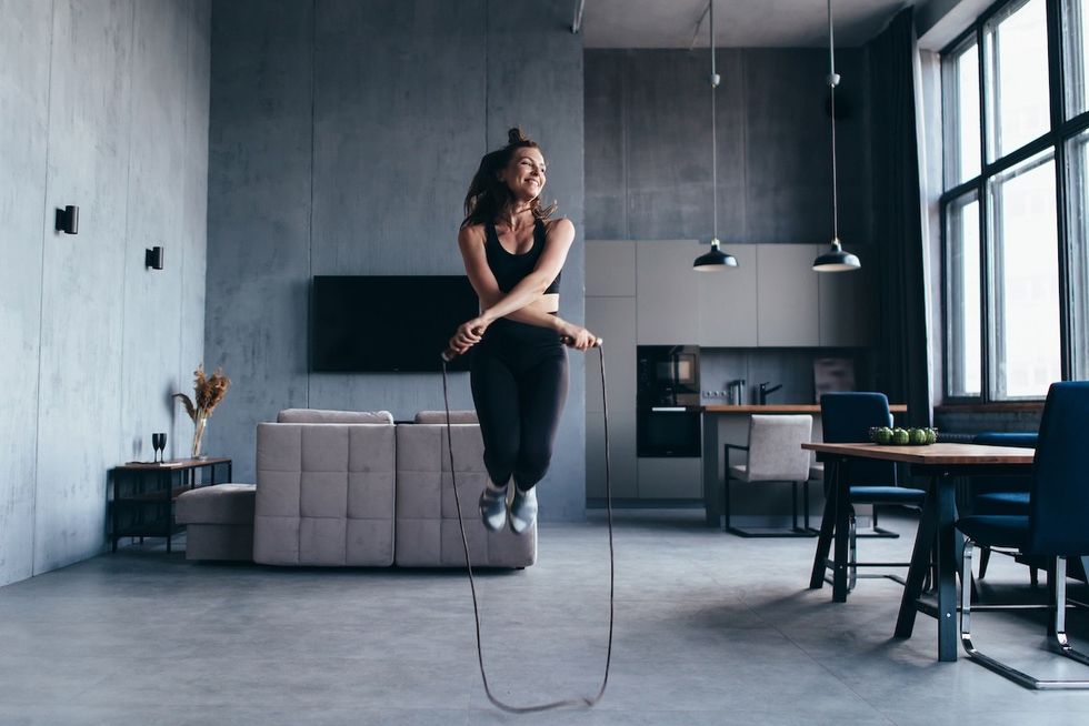 woman doing double-under jump rope in her apartment