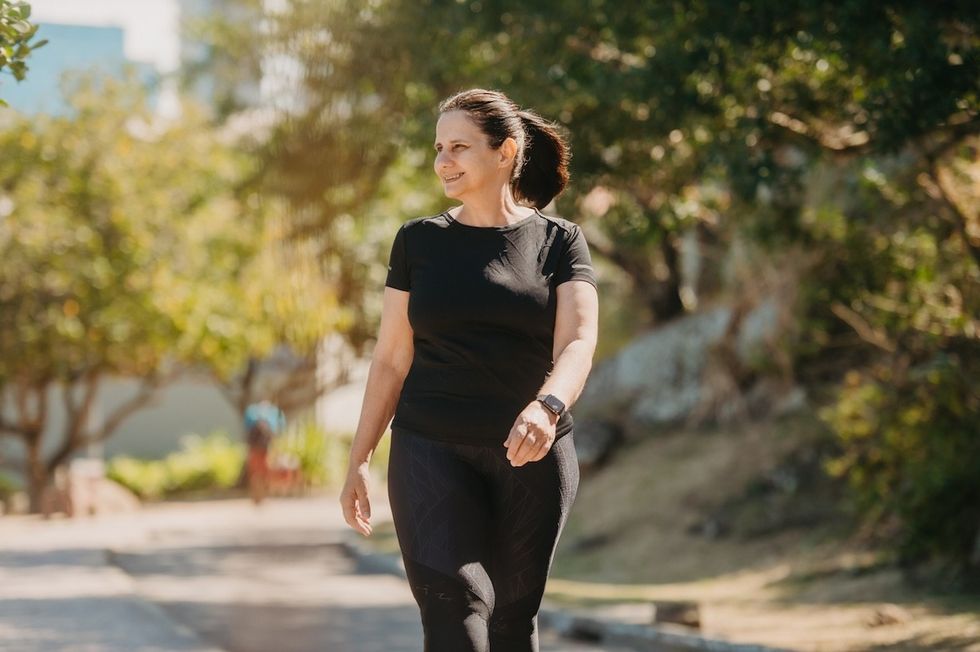 woman in black workout clothes taking a walk outdoors