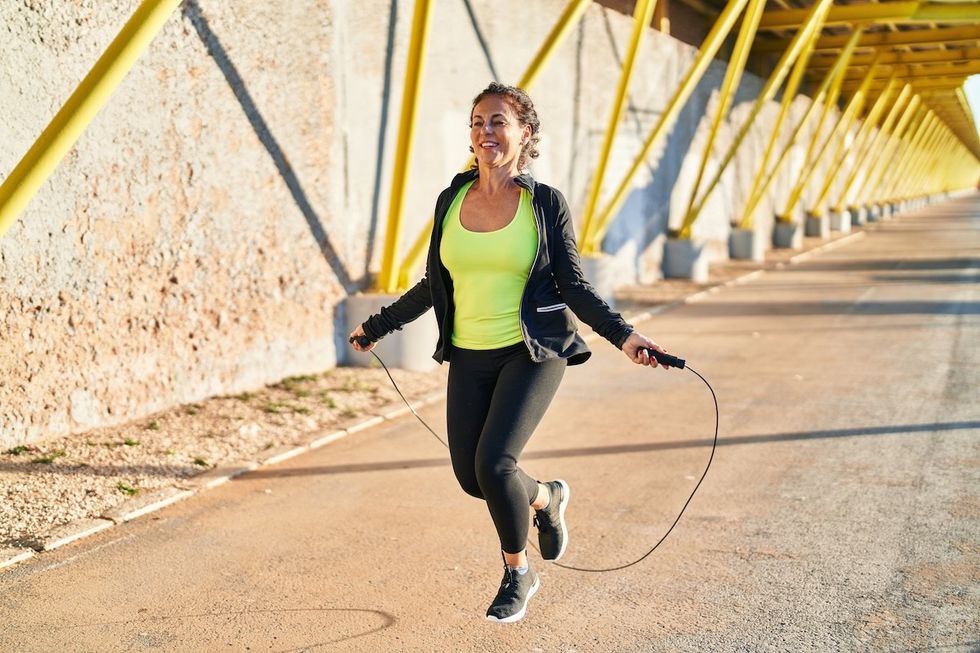 woman jumping rope on a bridge