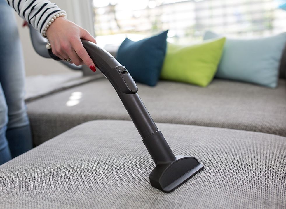 Woman vacuuming a couch