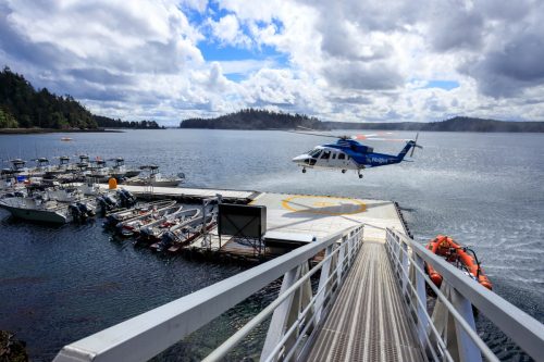 Langara Island, British Columbia, Canada - June 3, 2022: Helijet helicopter landing on the dock and helipad of Langara Island Fishing Lodge in Haida Gwaii, British Columbia, Canada.