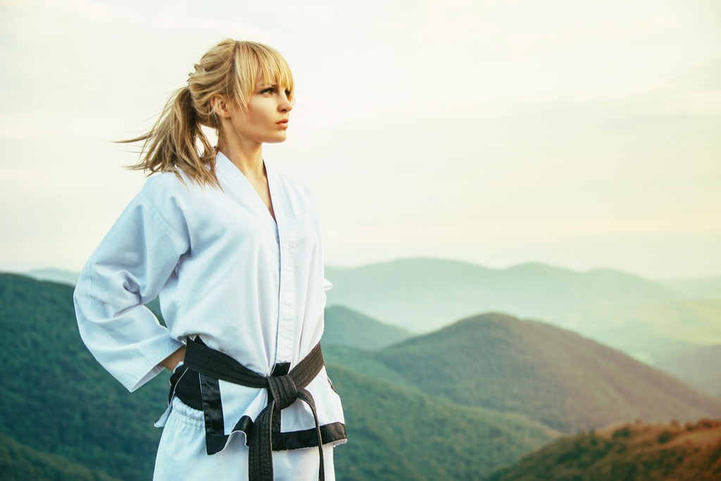 Beautiful black belt martial artist on a mountain top.