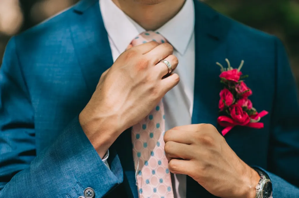 man holding his tie and a suit - how to dress over 50 