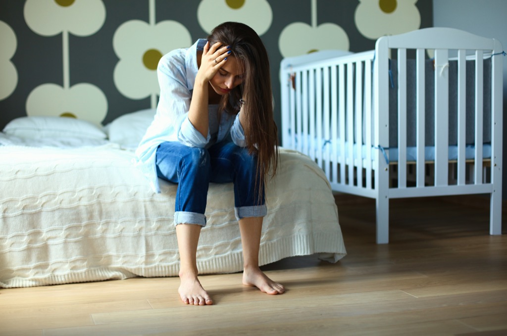 woman holding her head upset in a nursery, things divorced people know