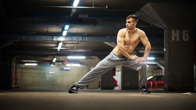 A man performing a three-way lunge exercise in the morning.