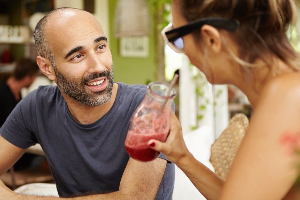 Couple talking and drinking a smoothie, signs your husband is cheating