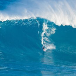 Laird Hamilton rides a giant wave.