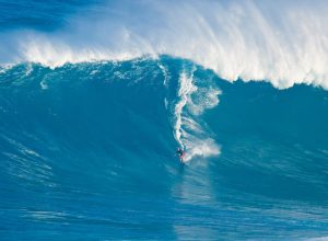 Laird Hamilton rides a giant wave.