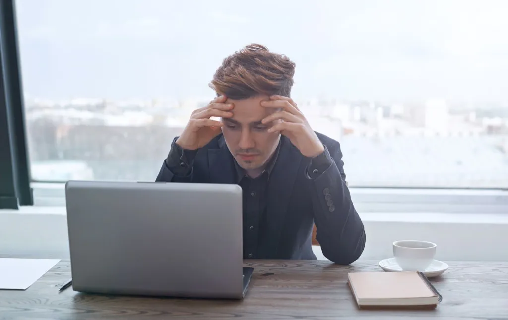 Man stressed at work, headache, hiring, more time, productivity 60 minutes