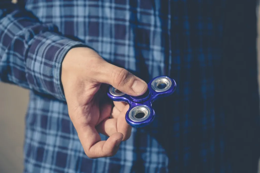 man holding a fidget spinner