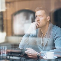 Man staring out window in the morning.