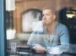 Man staring out window in the morning.