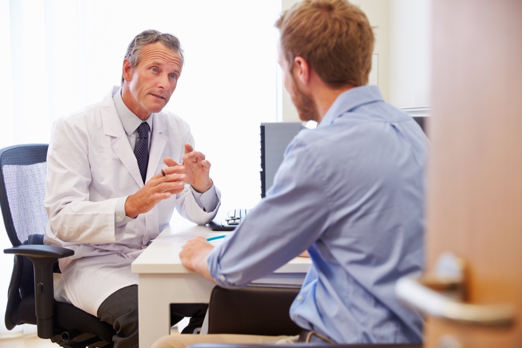 man talking to doctor in office, ways your body changes after 40