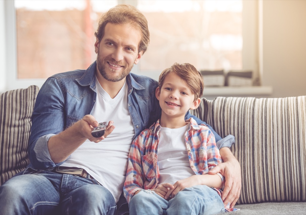 dad and kid watching tv 20 surprising ways fatherhood changes you