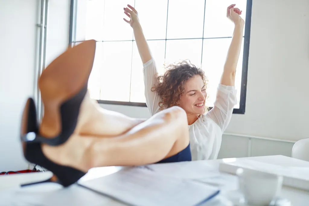 happy woman kicking up her heels at work, motivational monday quotes