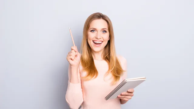 Smart woman holding pencil and notebook