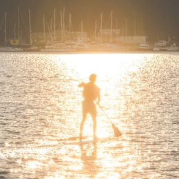 Man paddleboarding in Seattle, one of the healthiest cities in America.