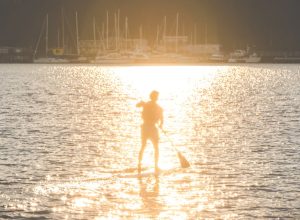 Man paddleboarding in Seattle, one of the healthiest cities in America.